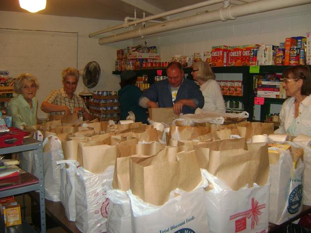 Volunteers serving in the pantry room pack and distribute bags to our clients.